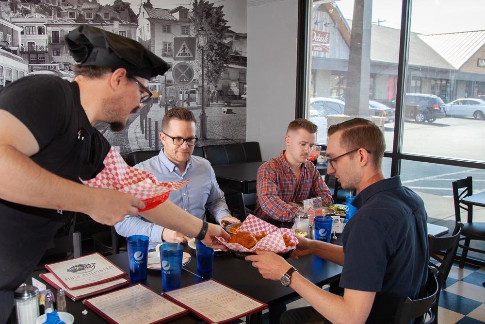 BURGERS AND BRANDING: Springfield Diner’s Omer Onder serves lunch to Jeremy Wells, Dustin Myers and Tyler Barnes of Longitude.